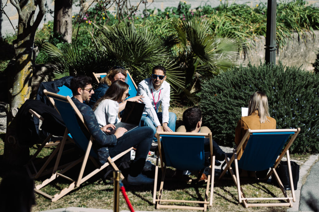 Attendees taking a break in Red Orbit chill seats enjoying sunshine.